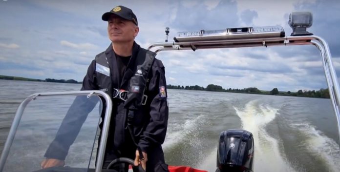 Policista řídí motorový člun na Nových Mlýnech