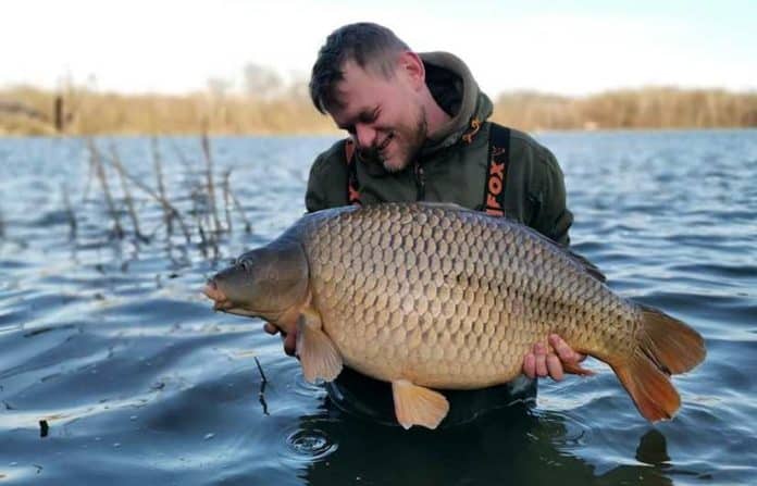 Rybář se raduje z úlovku při lovu kapra