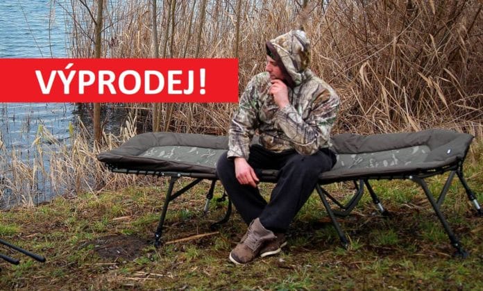 Rybář sedí na rybářském lehátku MAD a pozoruje vodu