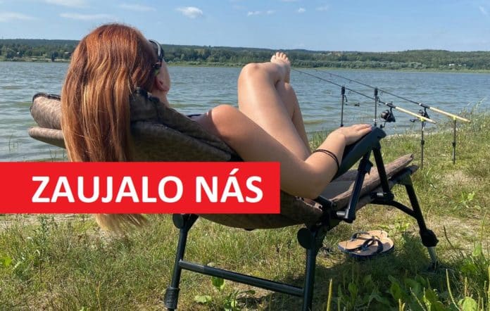 Rybářka sedí na rybářském křesle a pozoruje nahozené rybářské pruty