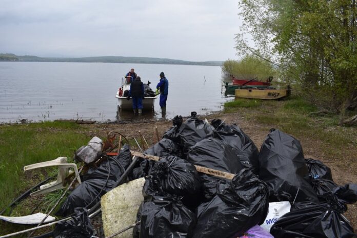 Rybáři sváží pytle s odpadky při úklidu Nechranické přehrady