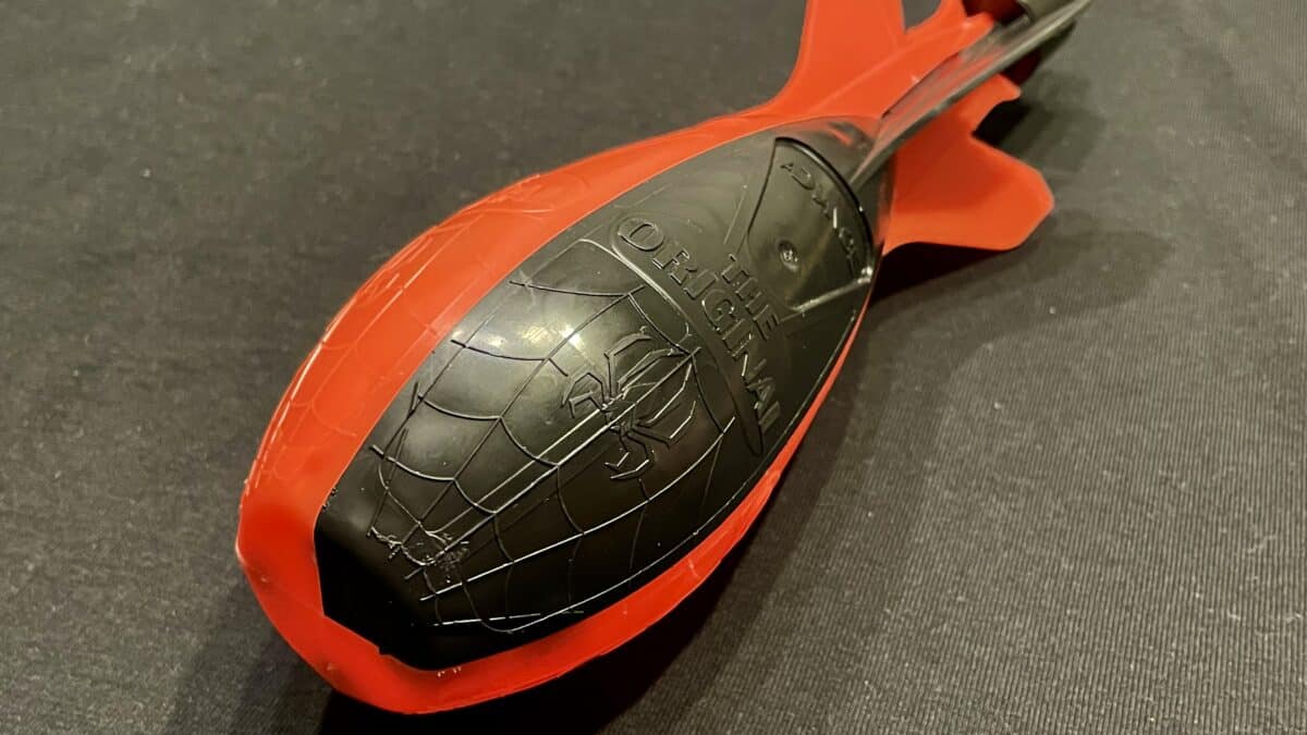 Red and black toy wheel close-up on a dark background, showing textured tire details and scuffs.