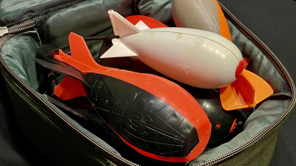 Close-up of orange and gray plastic toy parts with fins in a zippered bag.