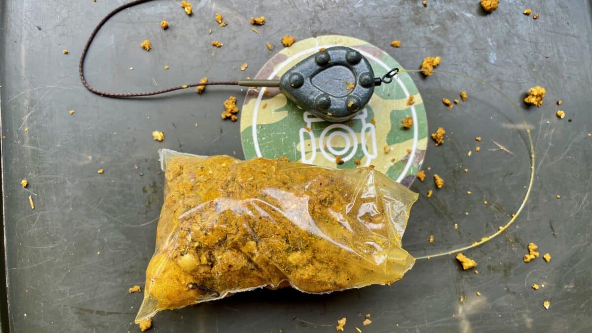 Plastic bag containing brown crumbly substance on a circular weighing scale, with scattered crumbs around it.