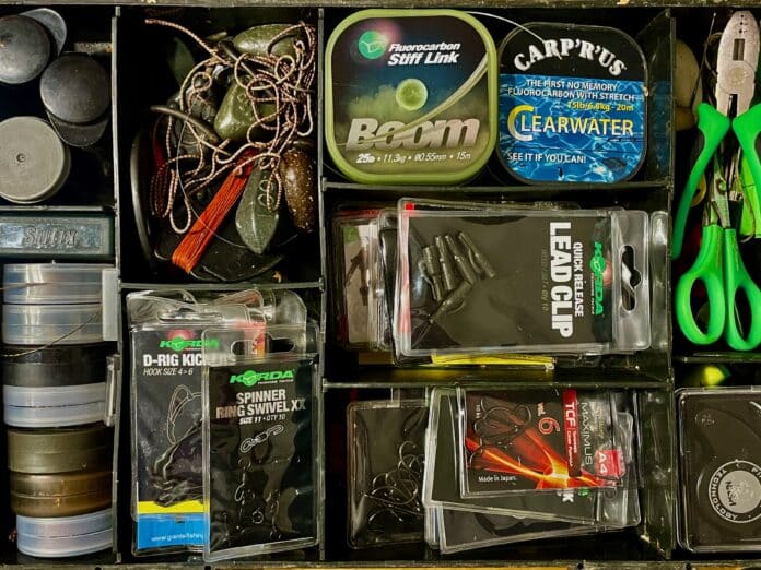 Organized tackle drawer with fishing lures, lines, and green scissors on the right side.